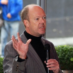 A photo of DailyDOOH editor Adrian Cotterill speaking into a microphone