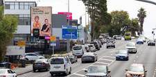 Shows a digital billboard operated by LUMO Digital, standing high above a road in New Zealand