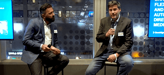 <p>Shows Karim Kanji and Chip Harding sitting side by side on stage at the DPAA Town Hall Event</p>