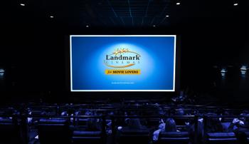 <p>An audience sitting in a Landmark Cinemas cinema, Landmark’s logo displayed on the big screen.</p>
