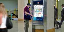 A man is standing in front of a wayfinding terminal in Philadelphia Suburban Station. The screen displays a map of the transit network and is interactive, allowing users to more easily find their own way.