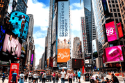 A vibrant Times Square scene featuring a towering San Diego tourism digital billboard with the message “San Diego is the place to show it,” surrounded by colorful advertisements, skyscrapers, pedestrians, and city traffic.