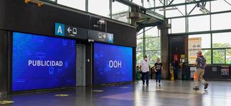 <p>Two large indoor screens standing side by side in a transit environment</p>