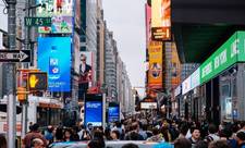 A busy street with different kinds of digital signage and DOOH installations. Metrics research can help the network owners understand their audiences.