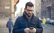 A man looking at his smartphone outside. Advertisers use browsing history to target their ads.